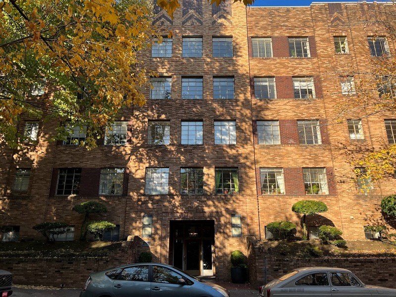 a large brick building with cars parked in front of it