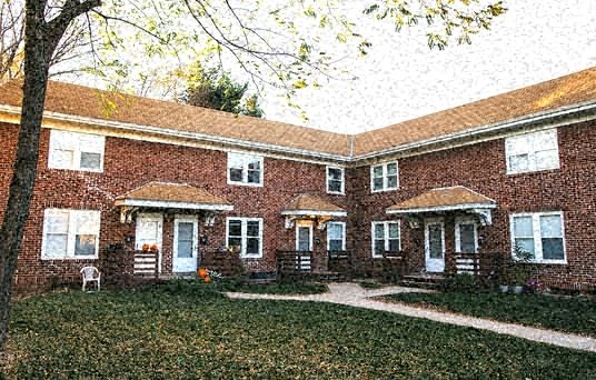 a large brick house with a yard in the rain