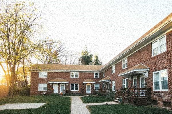 a large brick house with a tree in the background