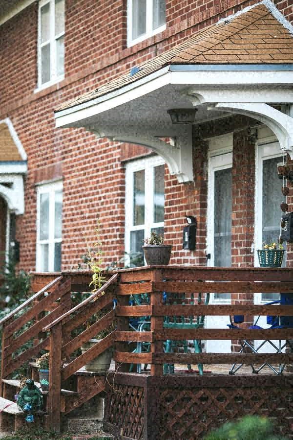 a red brick house with a wooden deck
