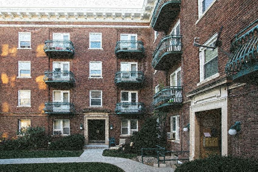 a brick building with several balconies and a courtyard