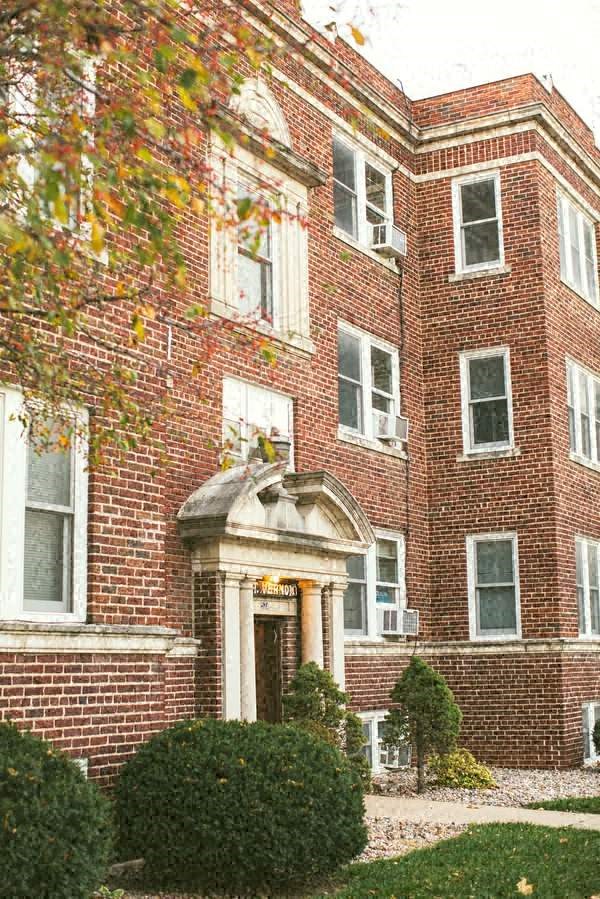 a red brick building with a porch and a door