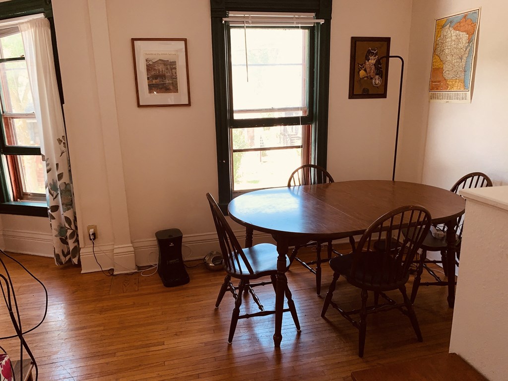 a dining room with a wooden table and chairs
