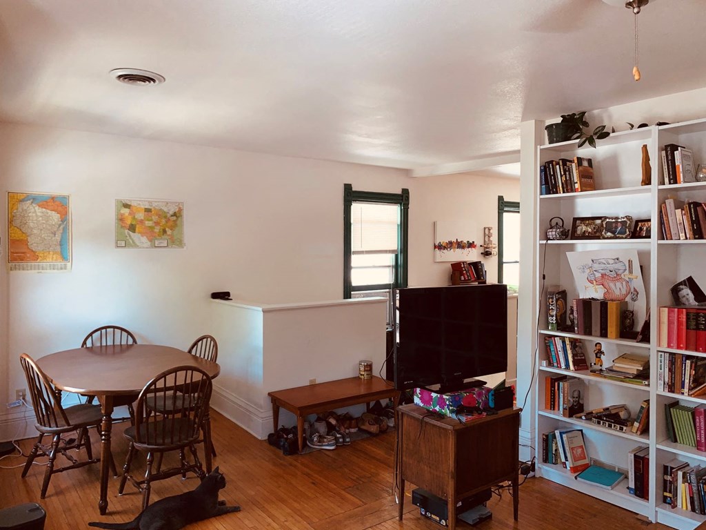 an empty living room with a dining room table and a tv