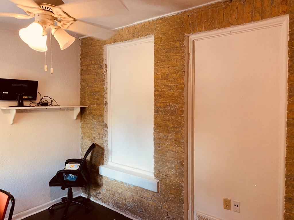 a room with a window and a desk with a chair