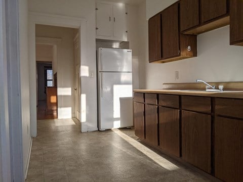 a kitchen with a stainless steel refrigerator and wooden cabinets