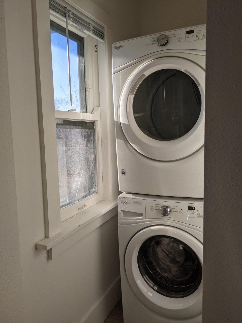 a small laundry room with a washing machine and a window