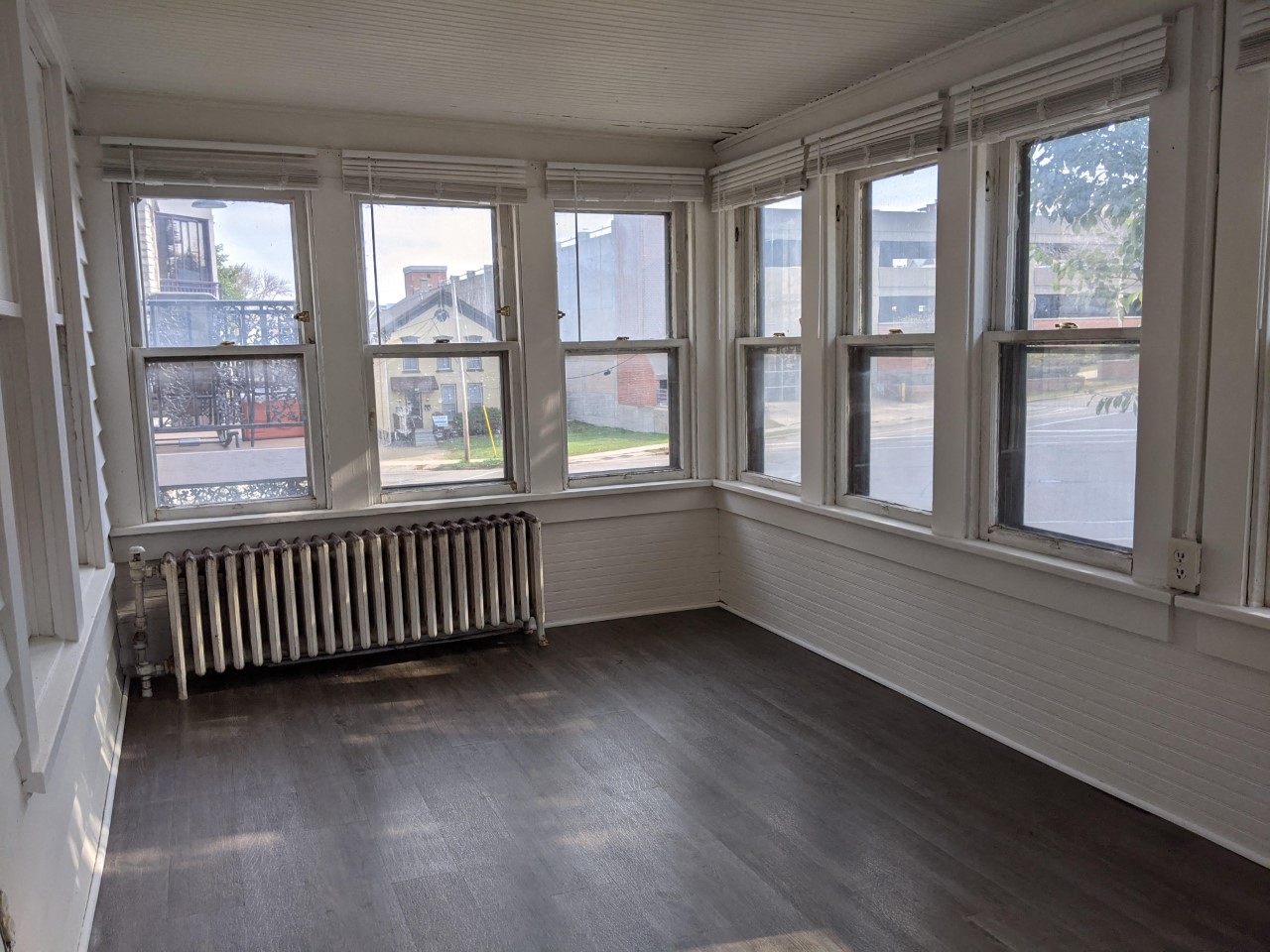 an empty room with a radiator and many windows