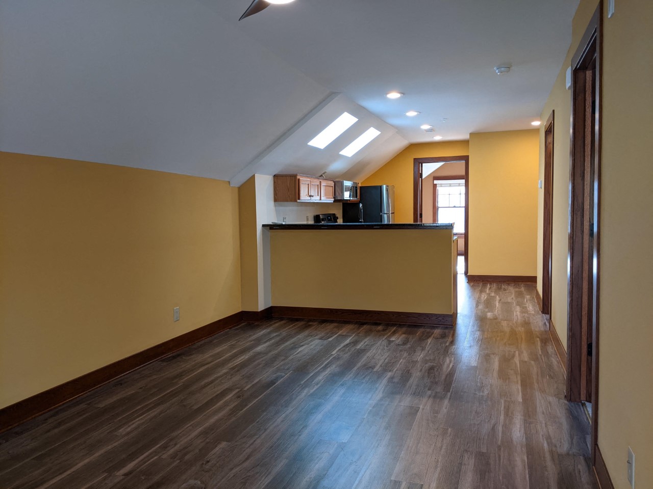 an empty living room with yellow walls and wood floors
