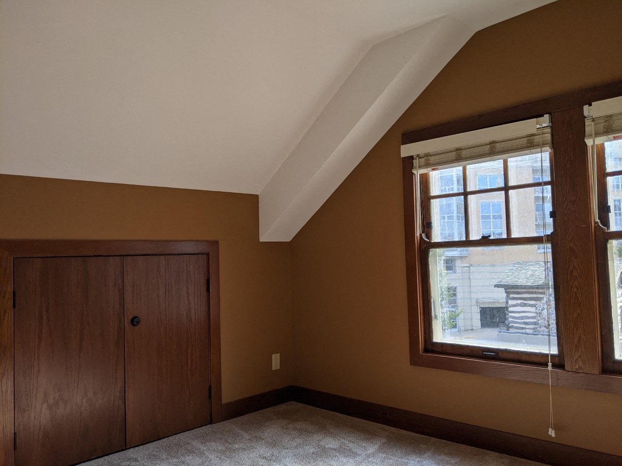 an empty bedroom with a large window and a door