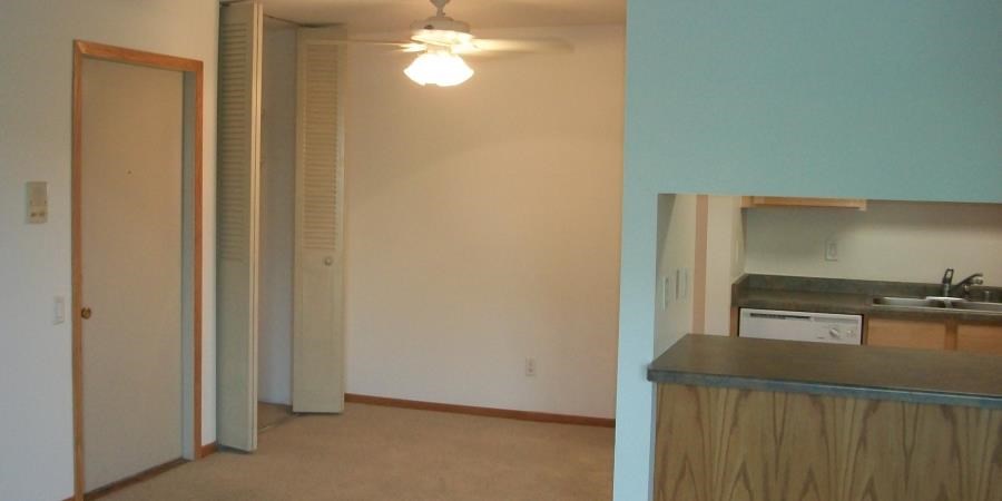 an empty room with a kitchen and a sink