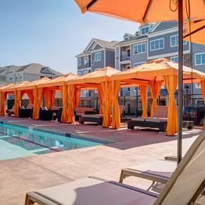 a group of orange umbrellas sitting next to a swimming pool