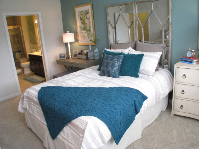 a blue and white bedroom with a bed and a bathroom