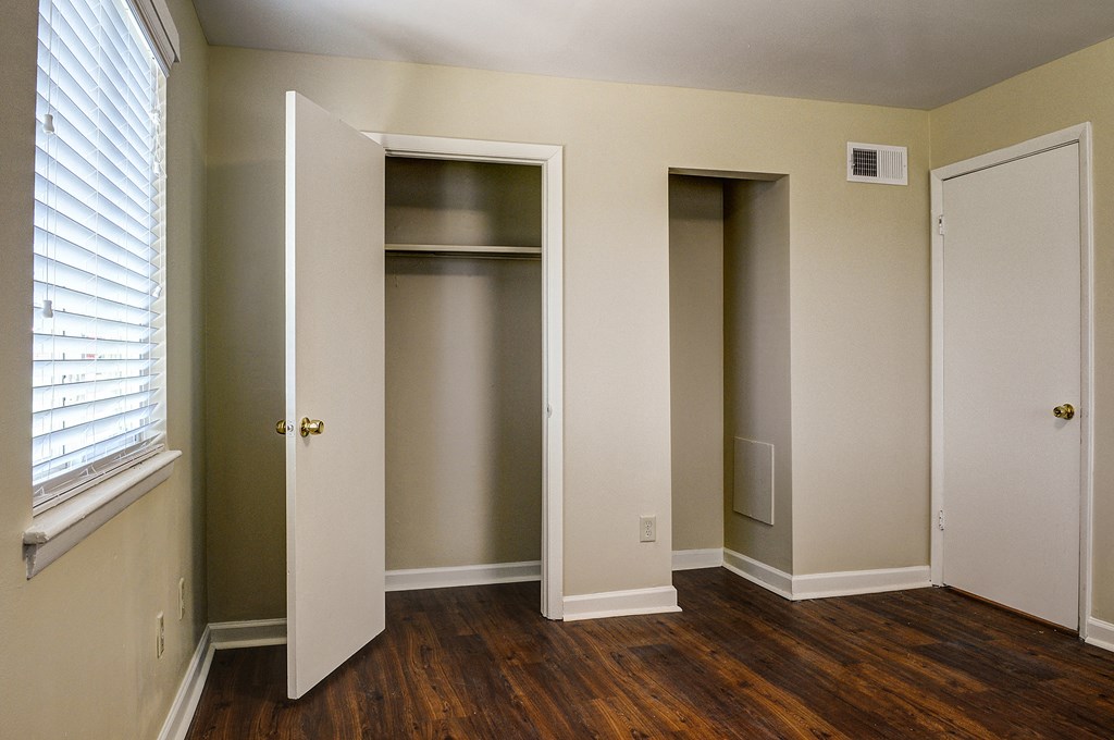 an empty room with three closets and a window