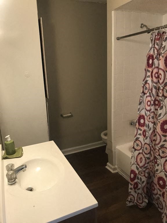 A white sink with a green soap dish and a floral shower curtain.