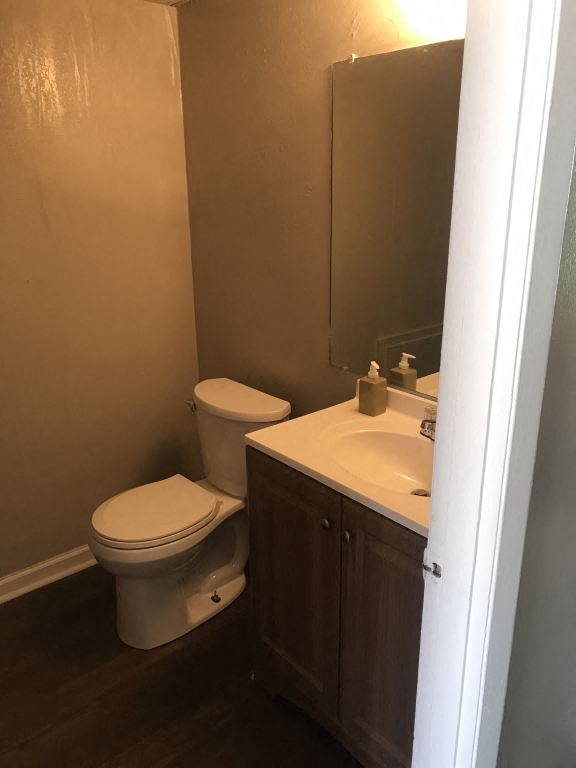 A white toilet sits next to a sink in a small bathroom.