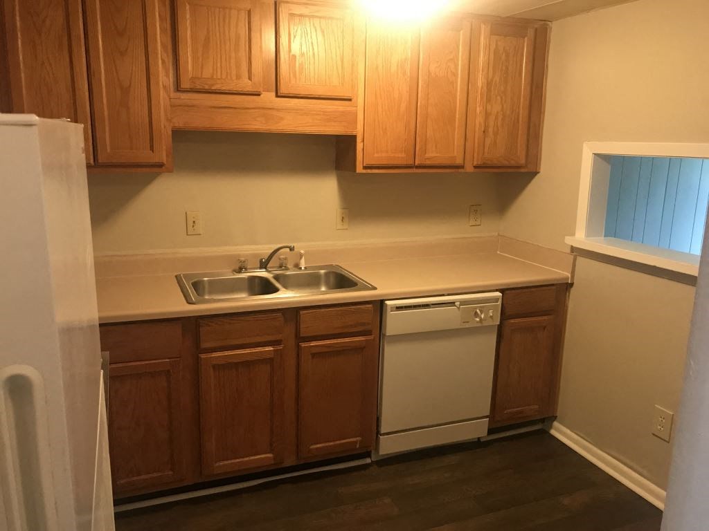 A kitchen with wooden cabinets and a white fridge.