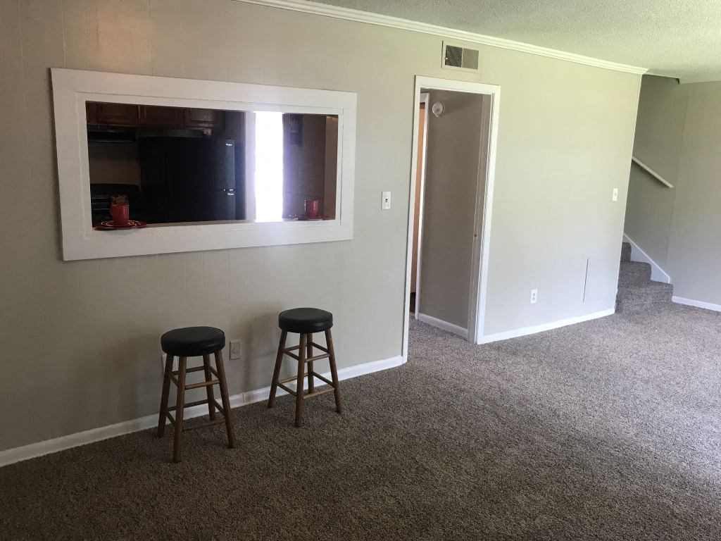 Two stools are placed in front of a wall with a mirror.