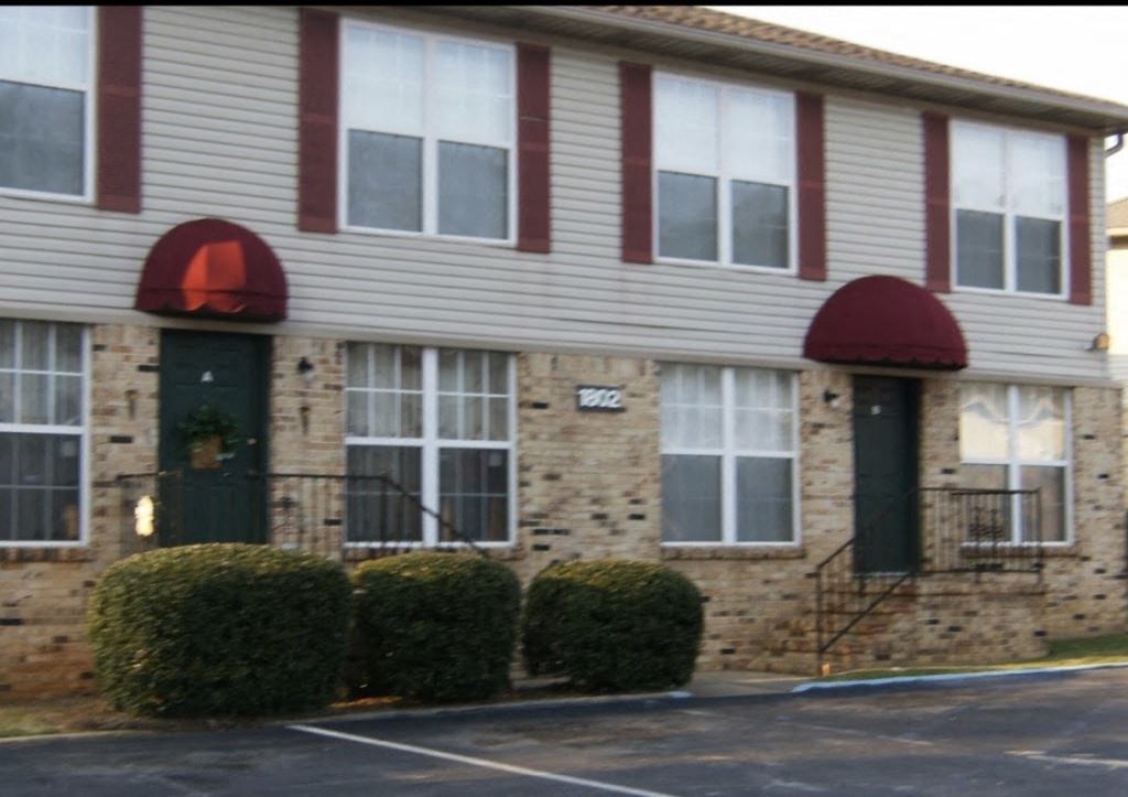 A building with a red awning and a green door.