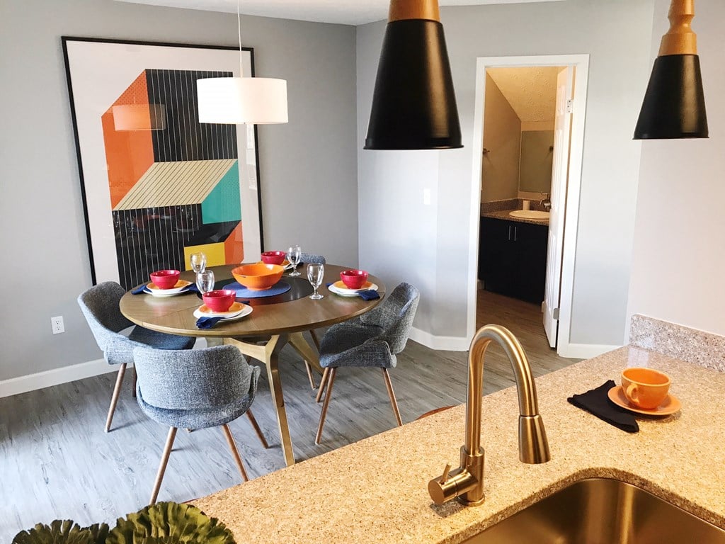 a kitchen and dining area with a table and chairs and a sink