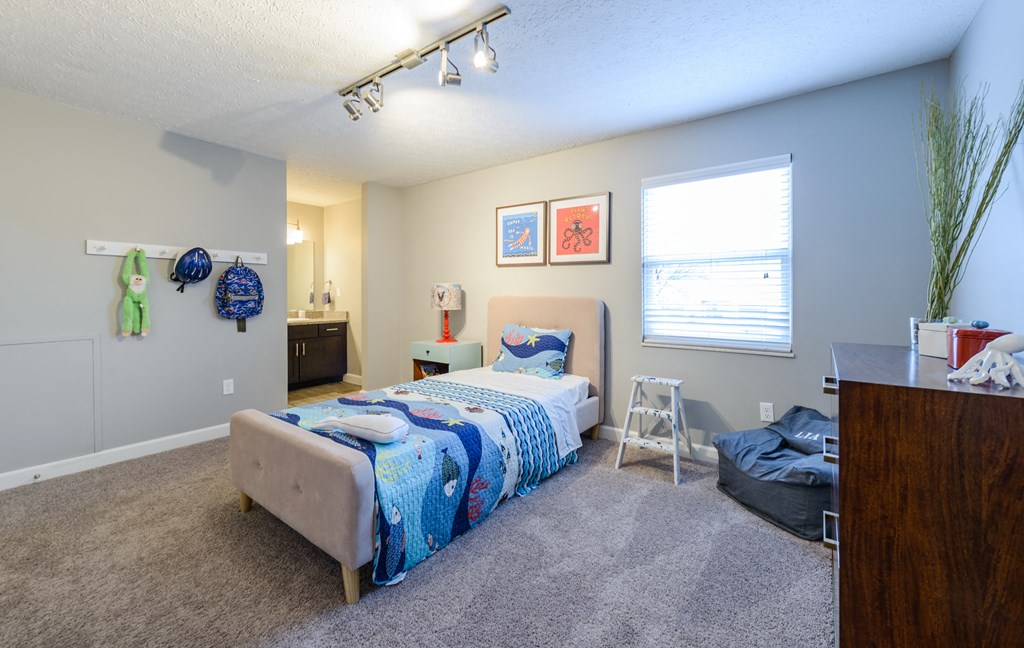 a bedroom with a bed and a dresser and a window