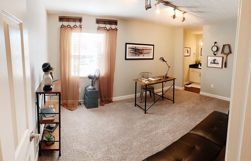 the view of a living room with a couch and a desk