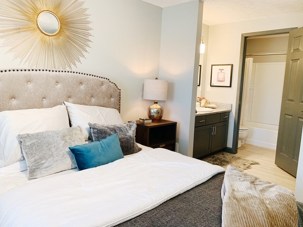 a bedroom with a large bed and a bathroom