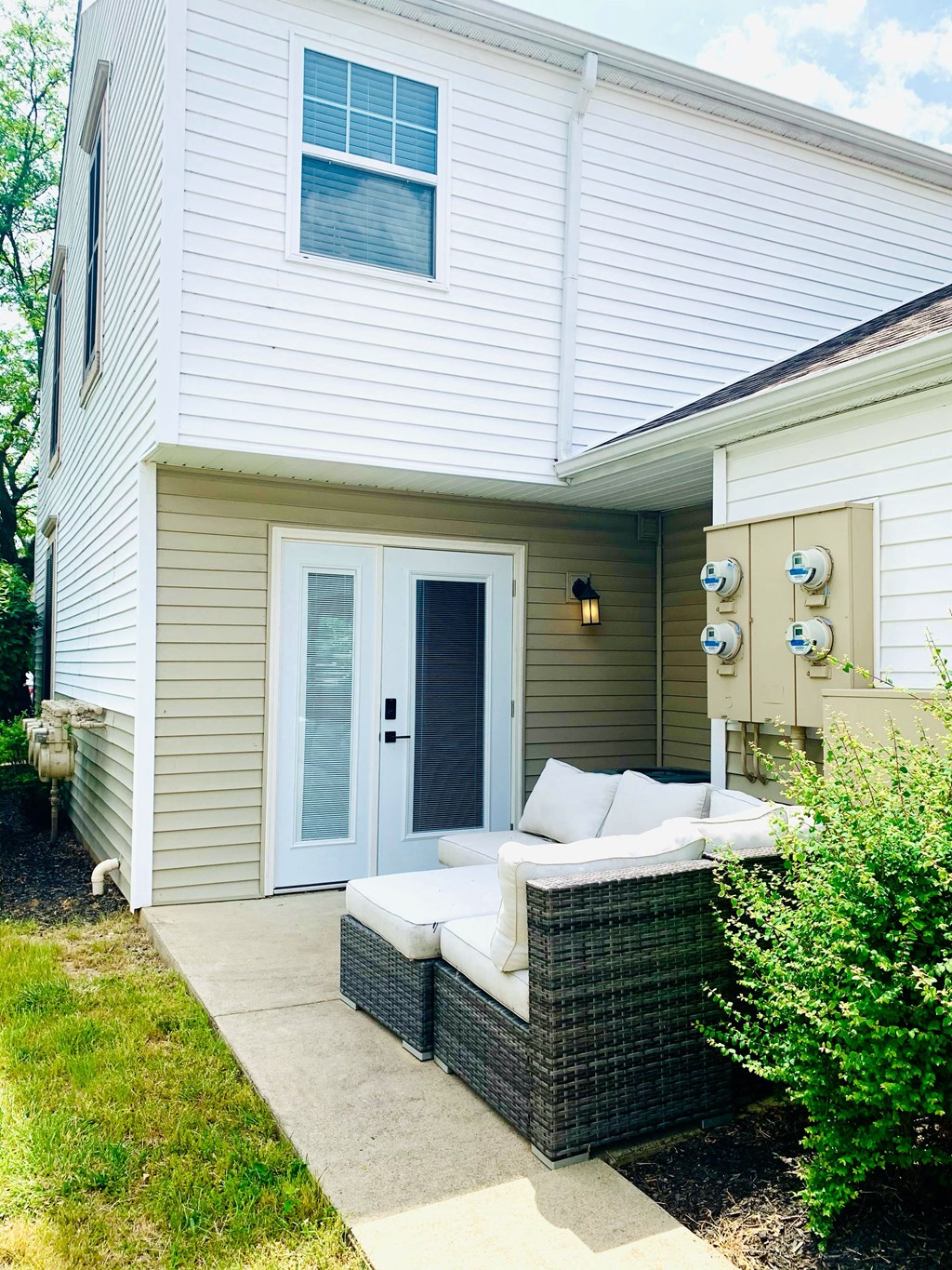 a patio with a couch in front of a house