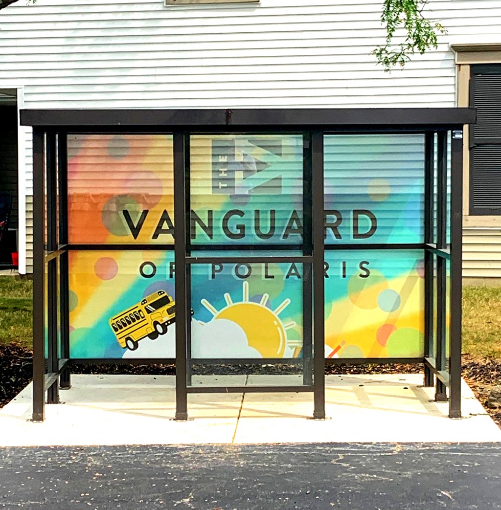 a bus stop with a mural on the side of a building