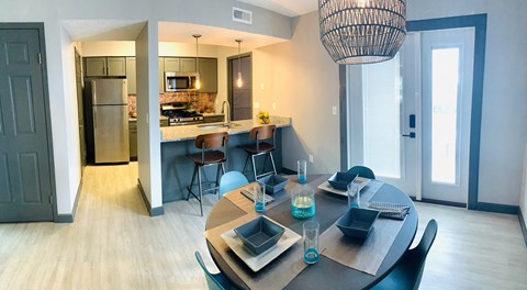 a dining room and kitchen with a table and chairs