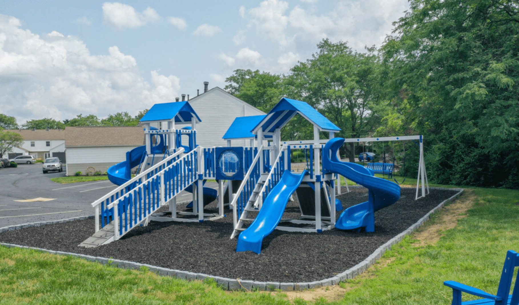 a playground with a set of slides in a parking lot