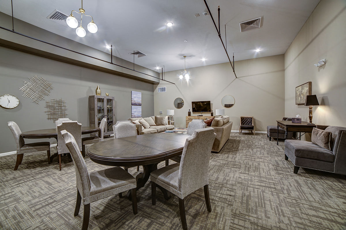 a large living room with a table and chairs