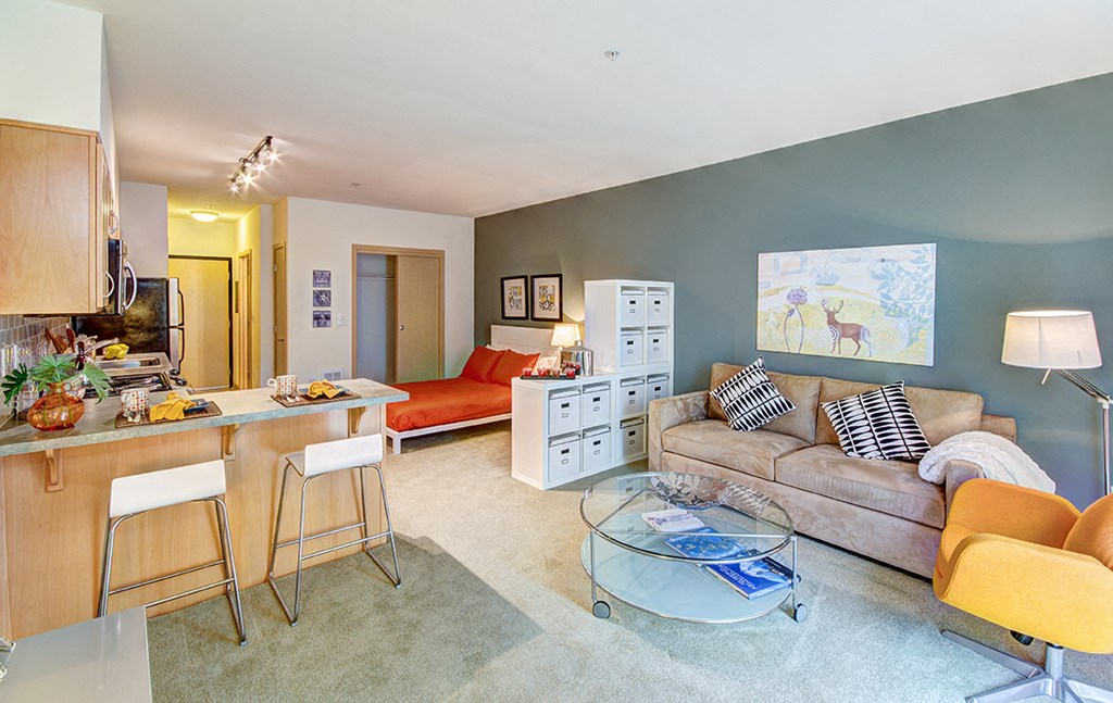 a living room and kitchen with a couch and a table