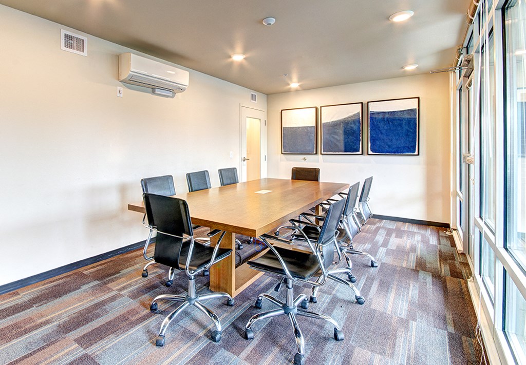 a conference room with a long wooden table and chairs