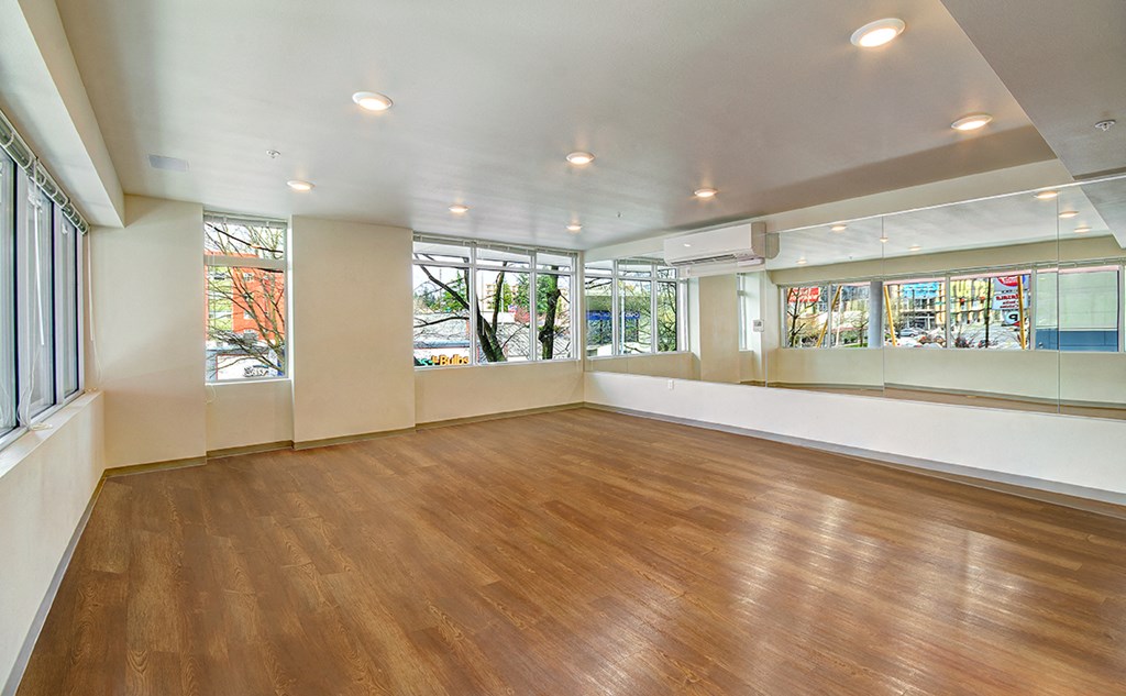an empty room with a hard wood floor and windows