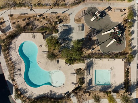 an aerial view of a swimming pool in the middle of a city