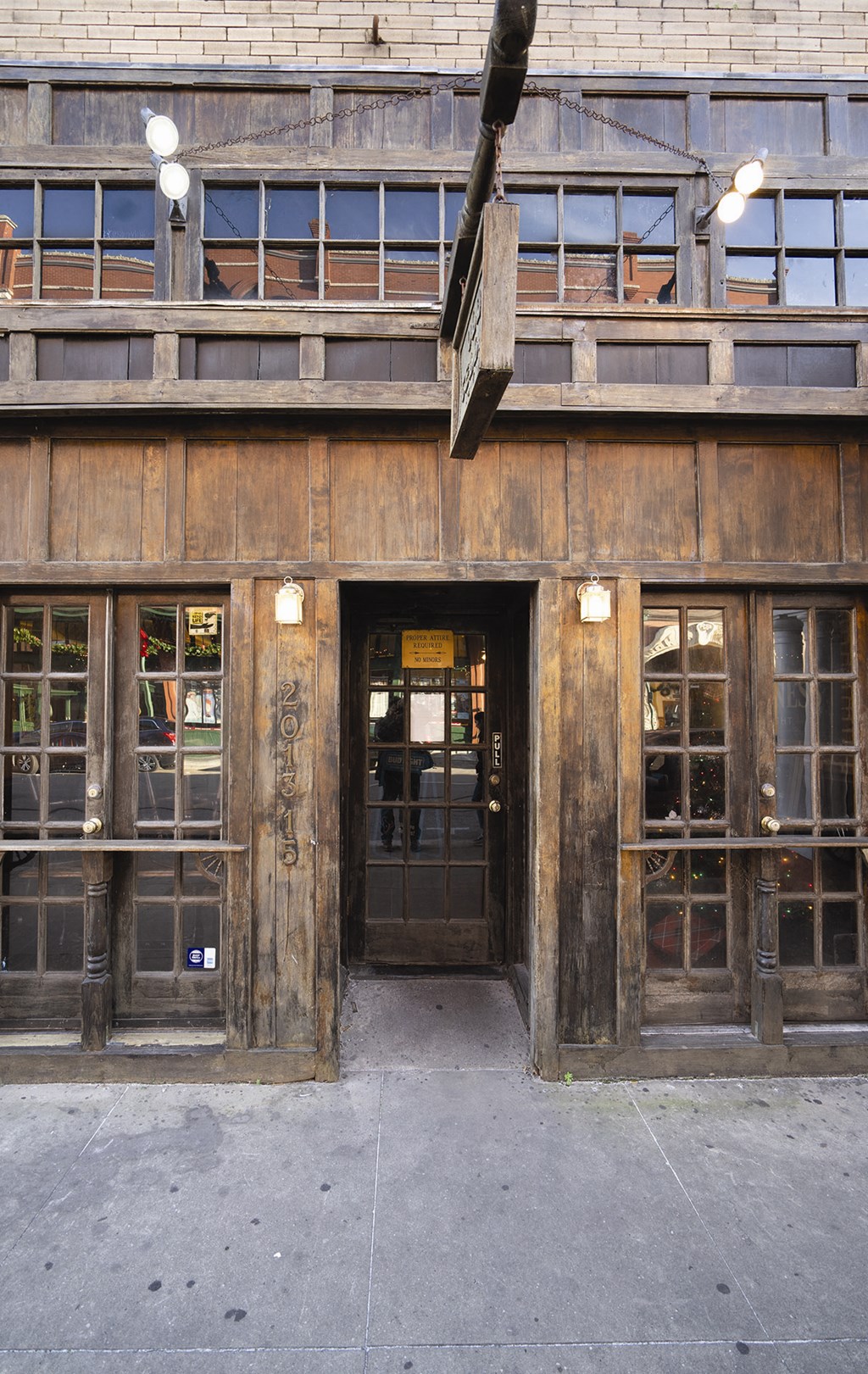the front of a building with a door and a street sign