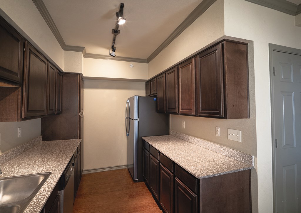 a kitchen with granite counter tops and a refrigerator