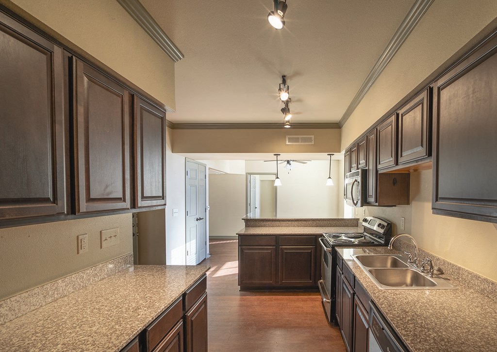 a kitchen with granite counter tops and wooden cabinets