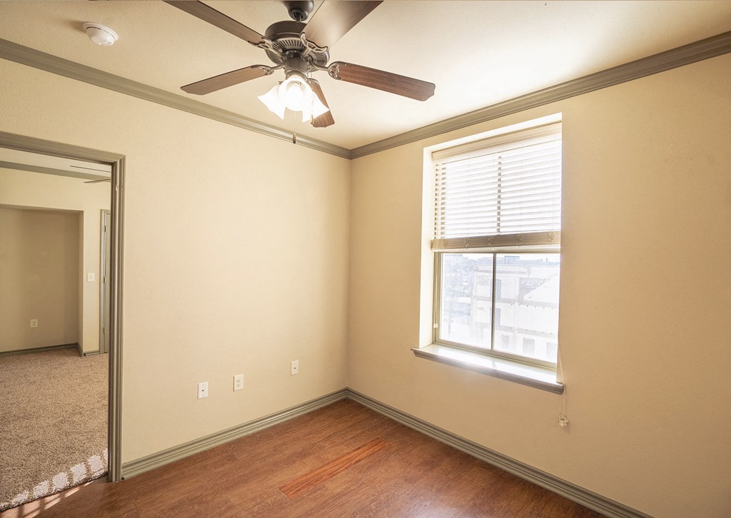 a bedroom with a ceiling fan and a window