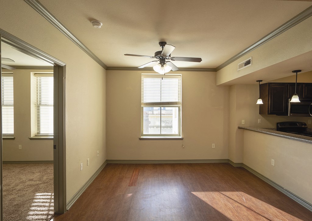 a empty living room with a ceiling fan and a window