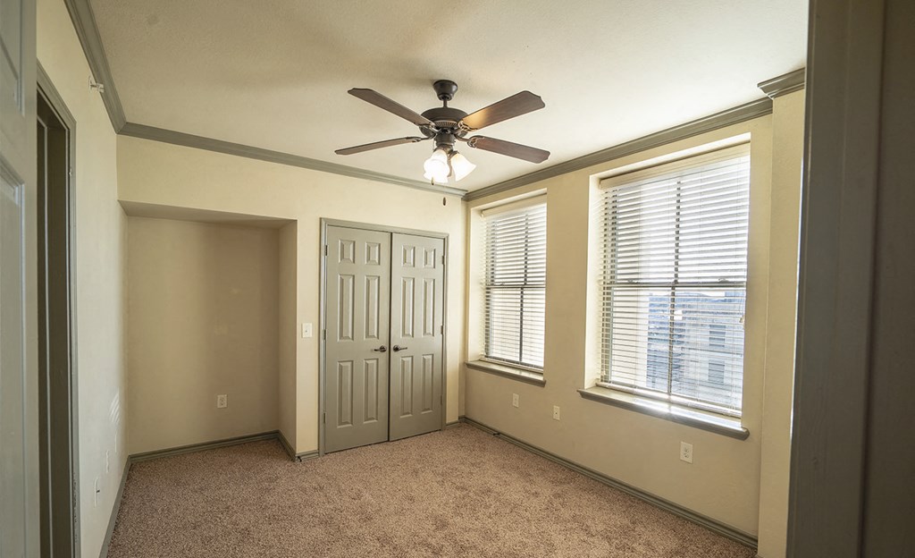 a room with a ceiling fan and a window and a door