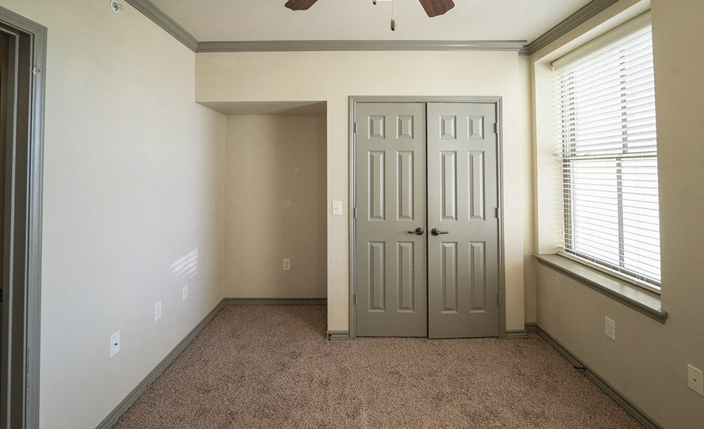 a room with a door and a window and a carpeted floor