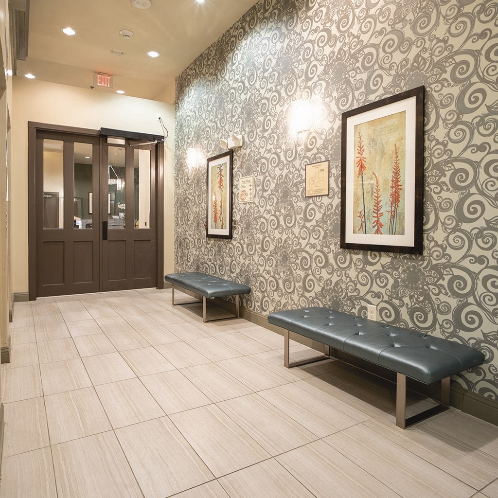 the lobby of a building with benches and a door