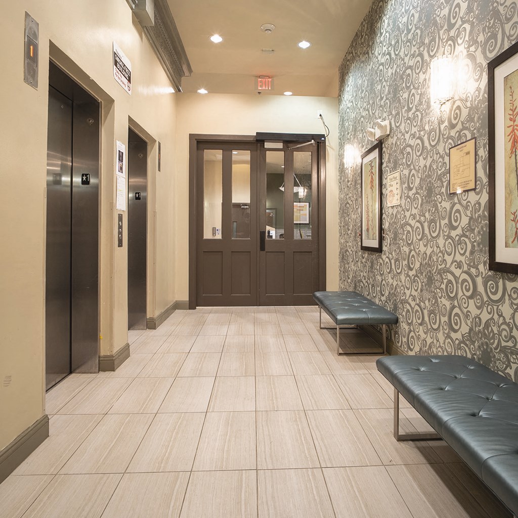 A hallway with a bench and two doors.