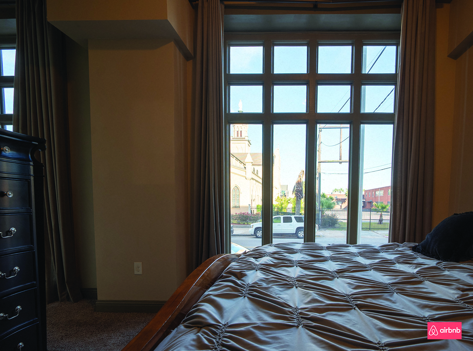 a bedroom with a bed and a large window