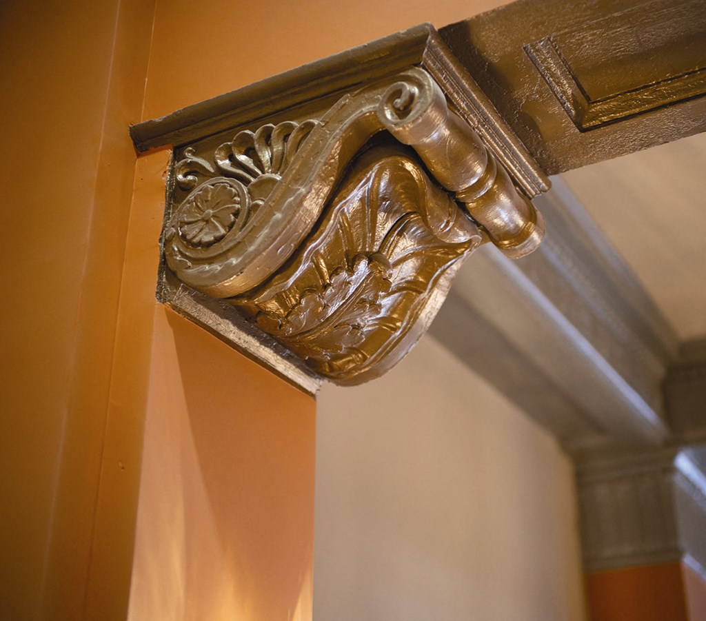 a bronze sculpture of a hand on a wooden pillar
