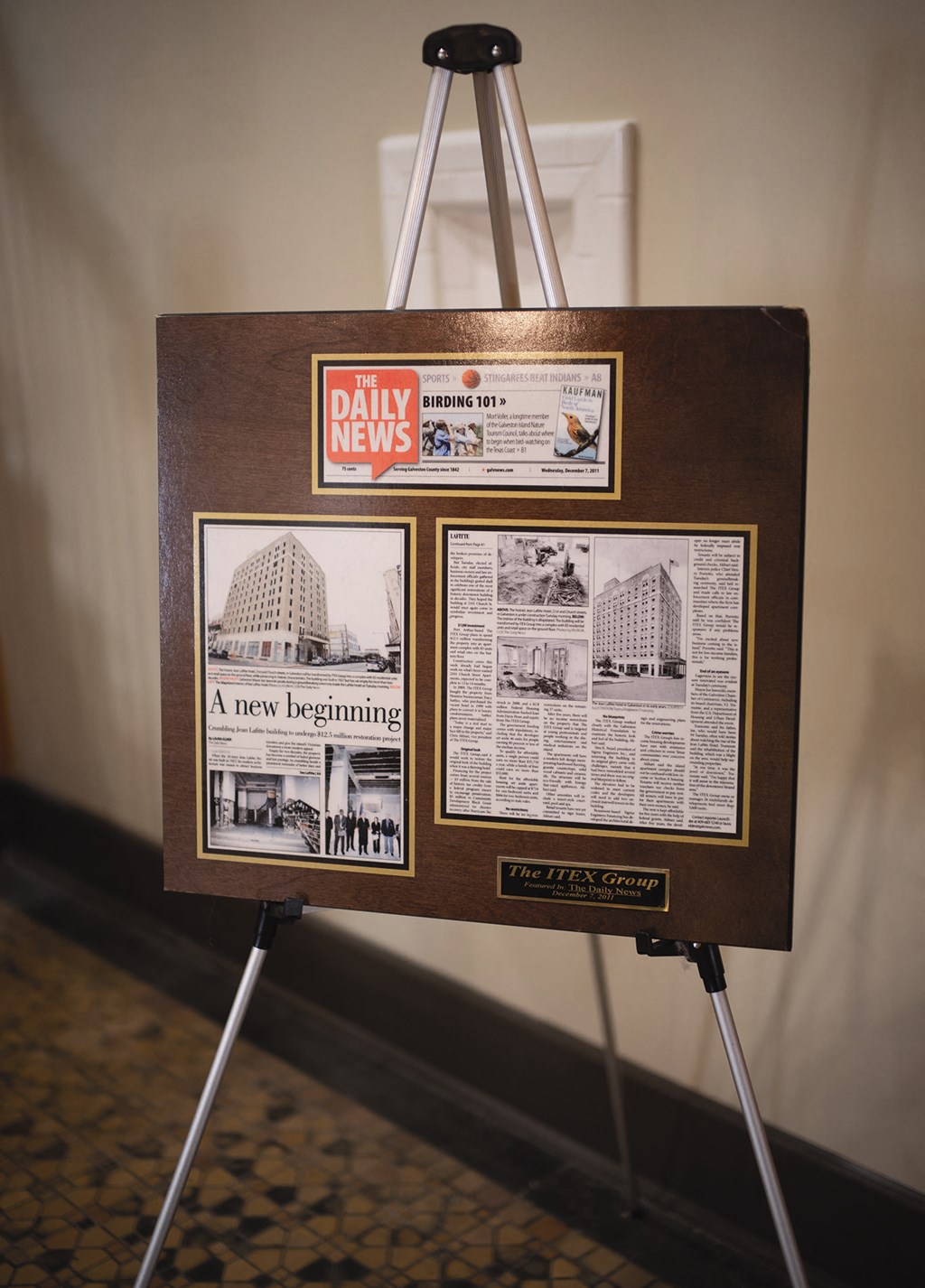 A wooden board with a Daily News logo and a picture of a building.