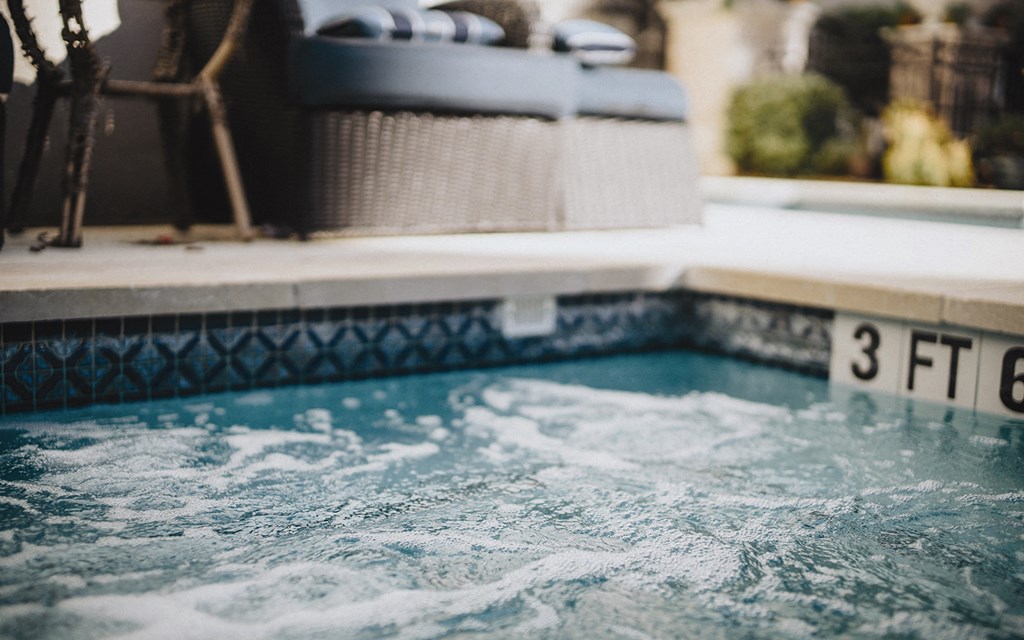 a swimming pool with a suitcase in the background
