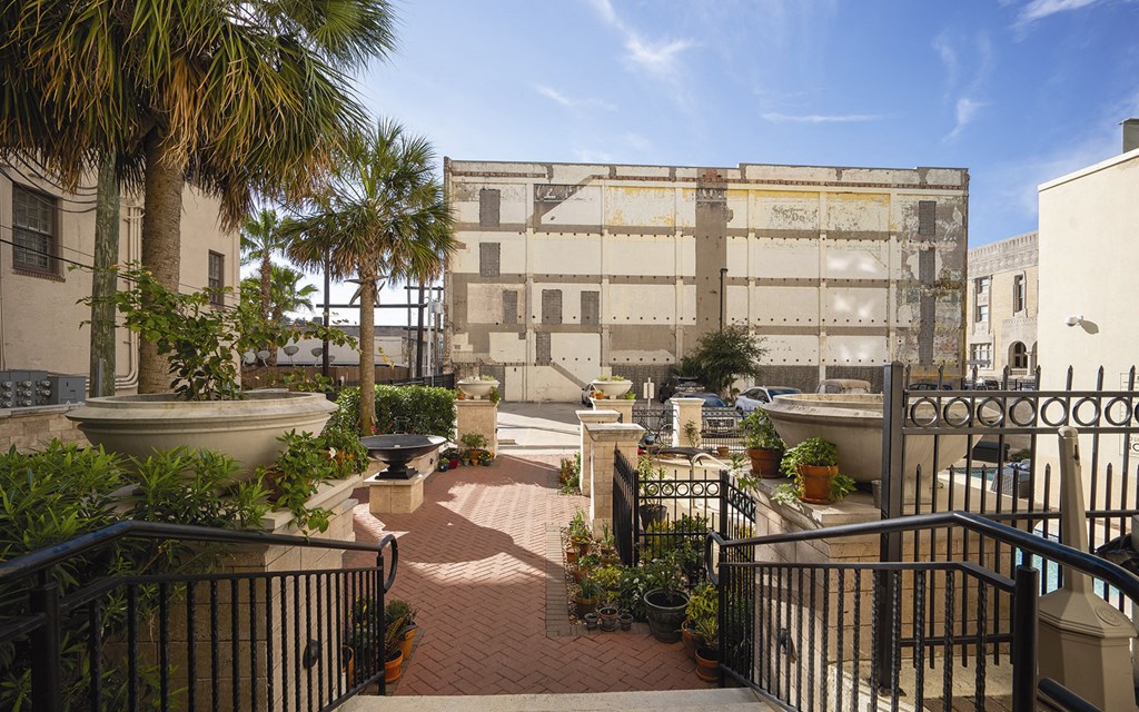 a courtyard with stairs and a building in the background